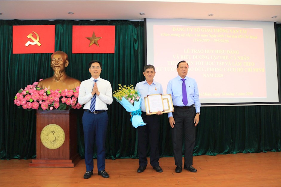 Giám đốc Sở GTVT Trần Quang Lâm trao Huy hiệu 30 năm tuổi Đảng cho đảng viên Lê Minh Hùng. Ảnh: Phương Linh